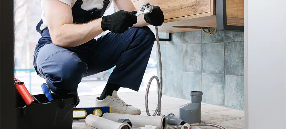 Plumber man fix repair service wraps fluoroplastic sealing material tape around faucet hose. Concept install plumbing in bathroom.