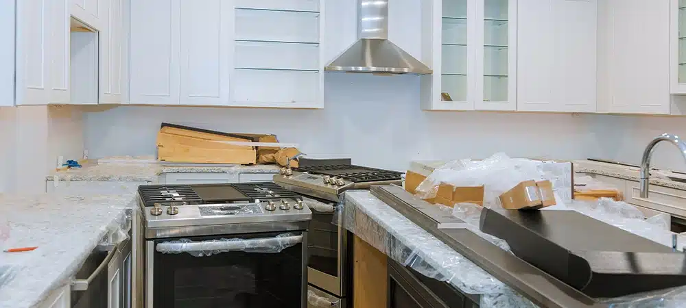 Interior of modern kitchen with all appliances on stove top, marble counter with kitchen white cabinets