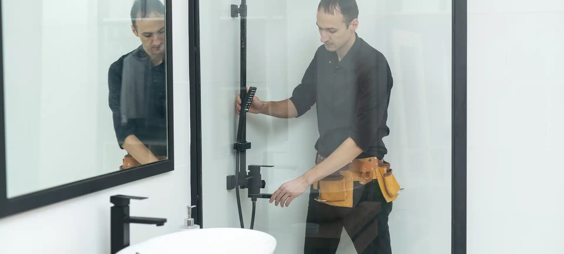 Plumber installing a shower cabin in bathroom