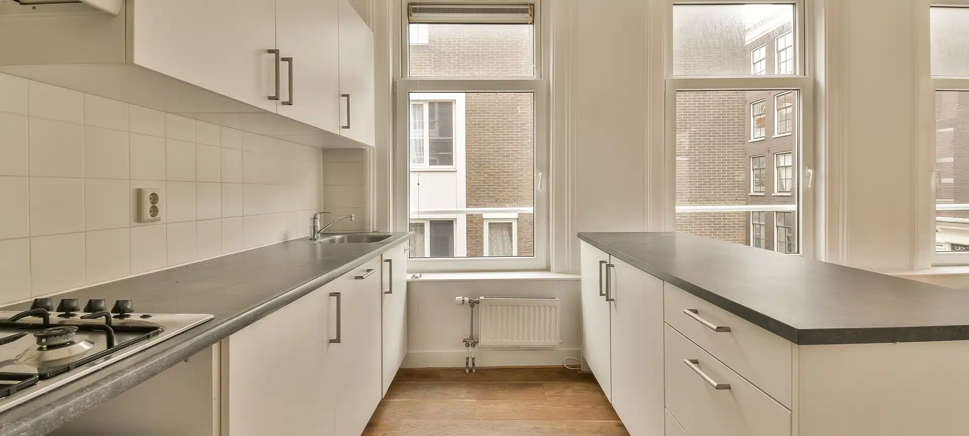 a kitchen with white cabinets and a window