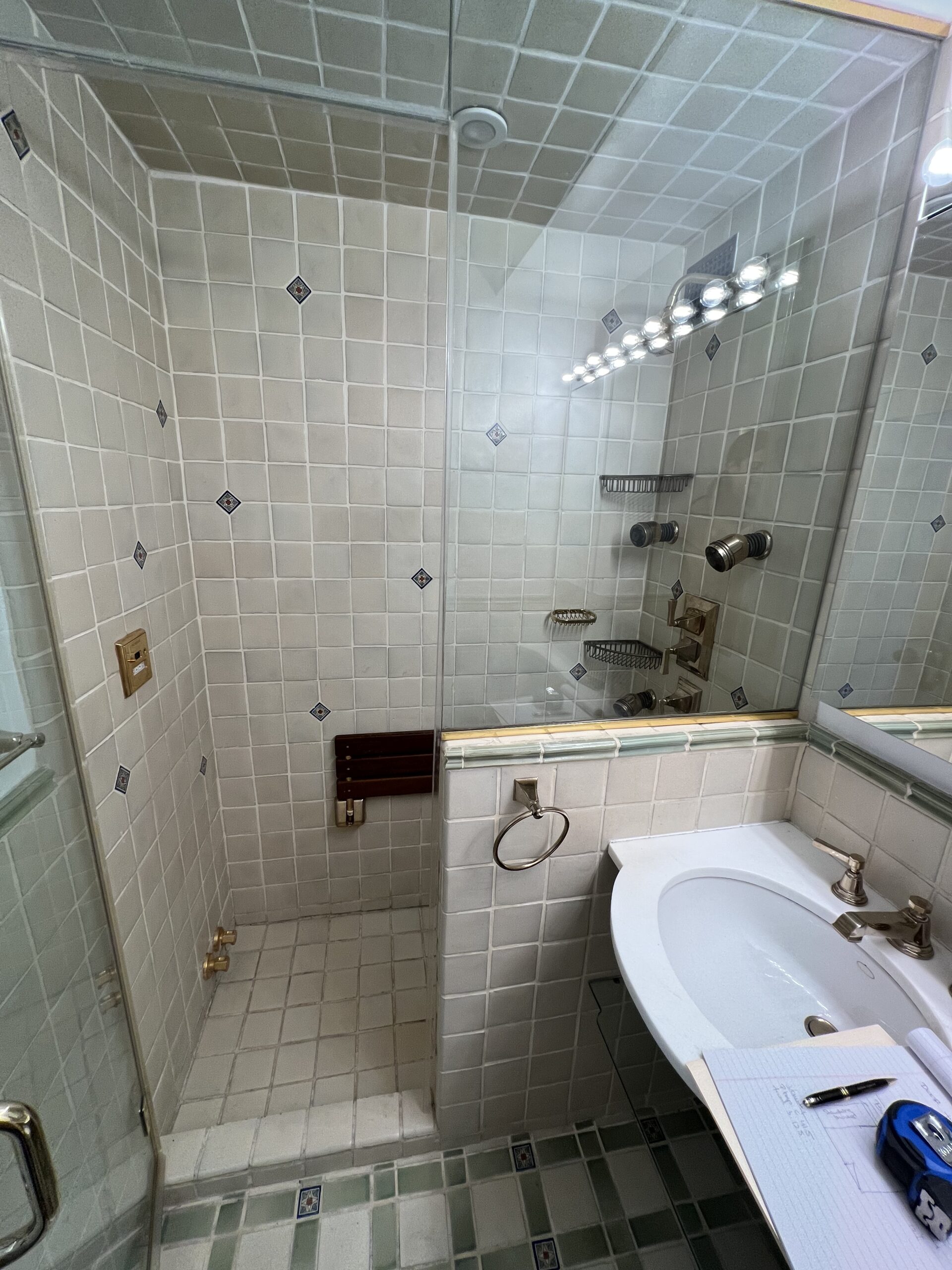 The bathroom at 15 West 12th Street before the renovation, with the steam shower, its body jets and wooden bench, and the console sink with its banjo counter