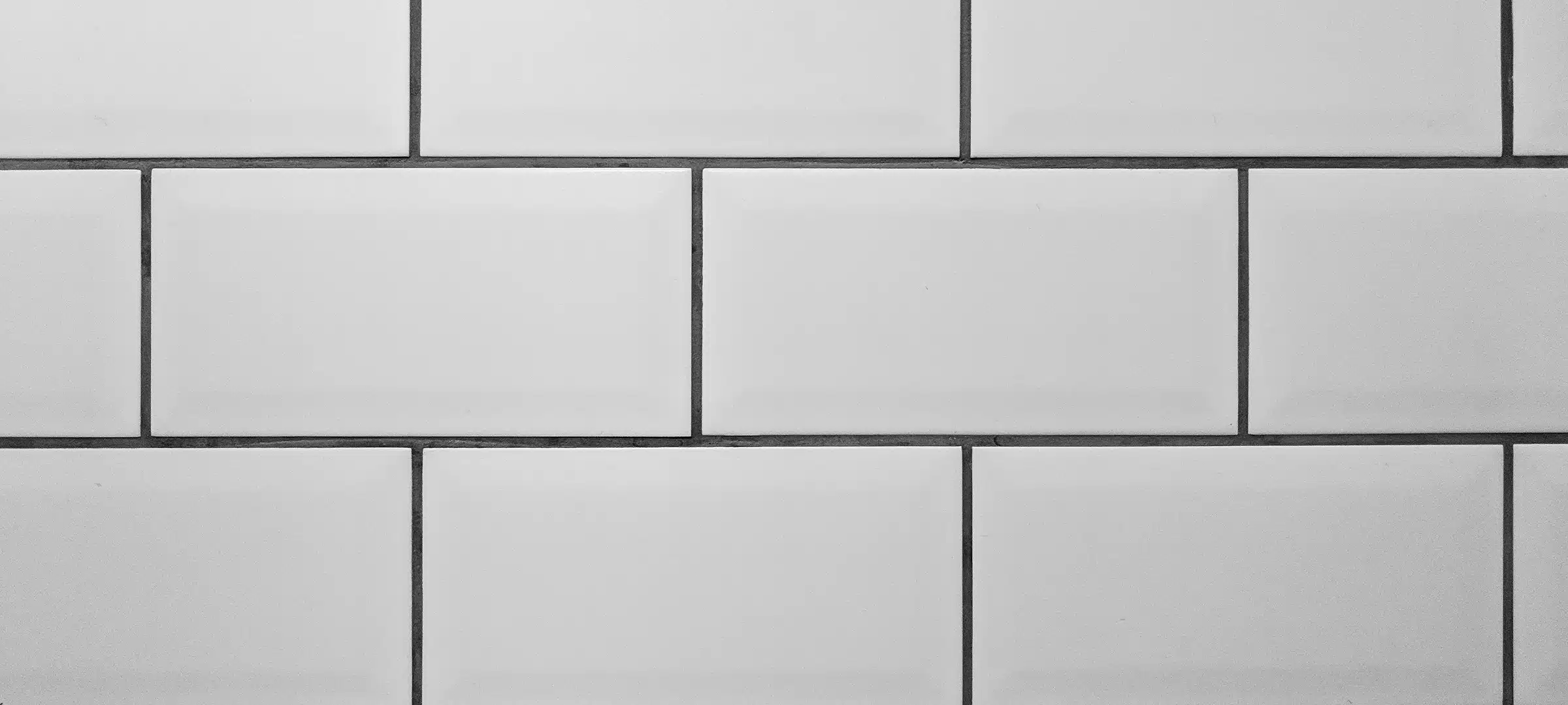 White metro tiles with grey grout. White rectangle tiled background