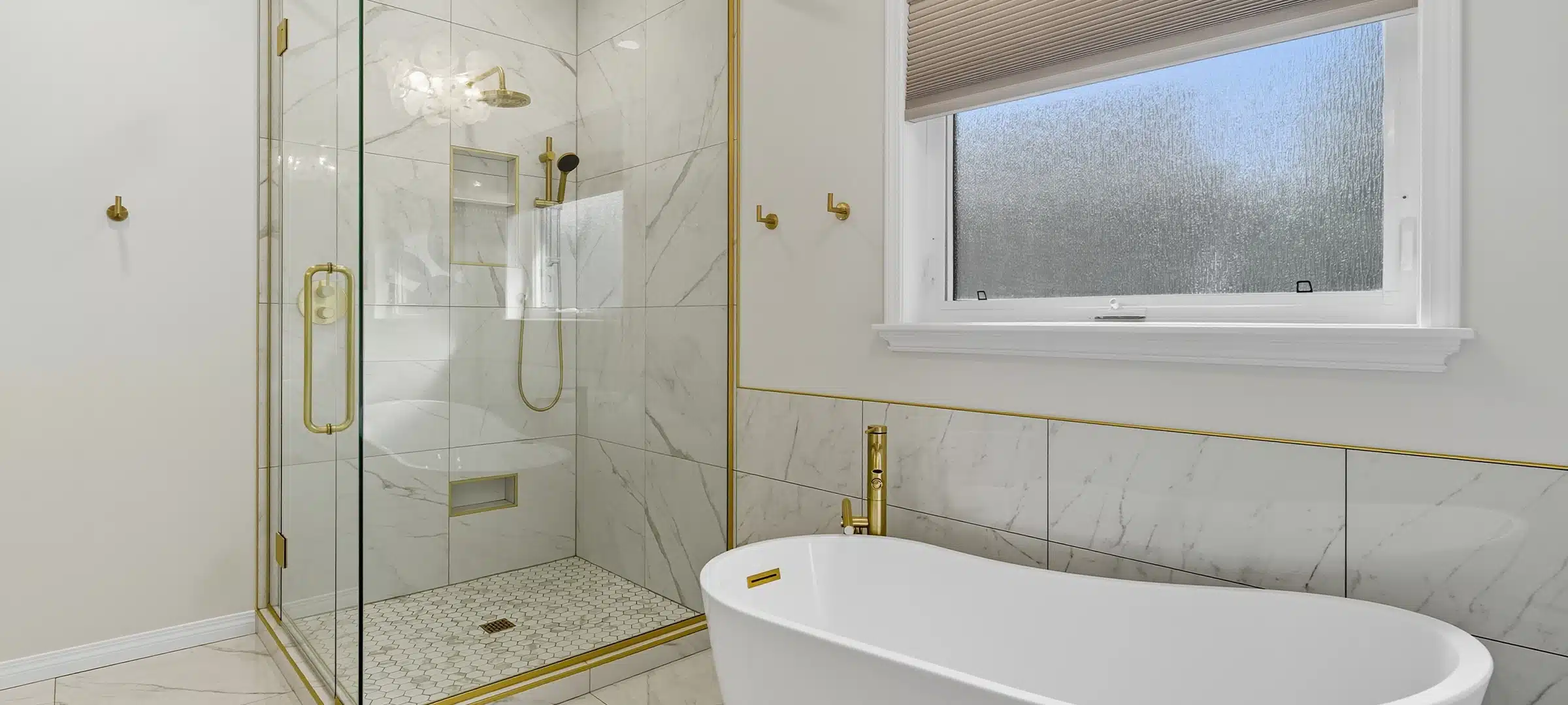 Bathroom with a gold shower stall and a white bathtub. The bathroom is clean and well-maintained, with a modern design