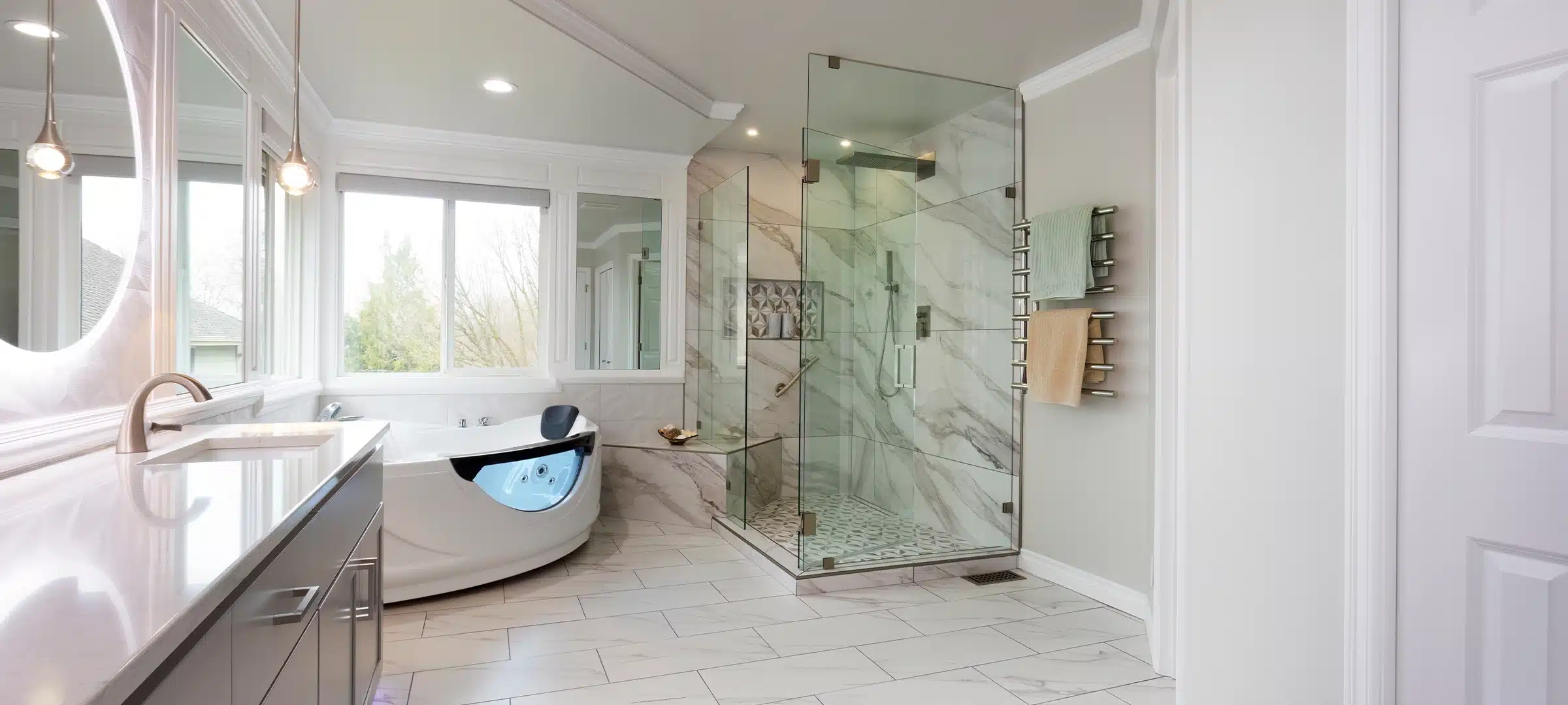Spacious modern contemporary master bathroom with jacuzzi hot tube, large glass walk in shower, new stone counter, wall, mirrors, lighting plus towel warmer rack