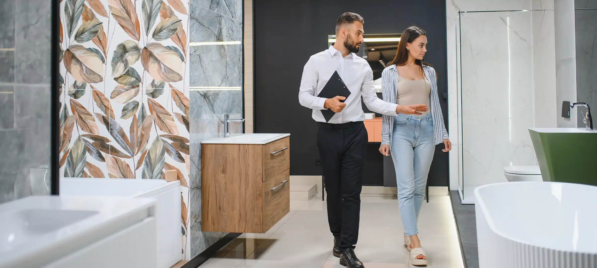 Smiling woman customer and sale manager showing client modern bathroom. Happy woman making purchase, choosing shower cabin, utensils for home bath room, plumbing seller helping, consulting.