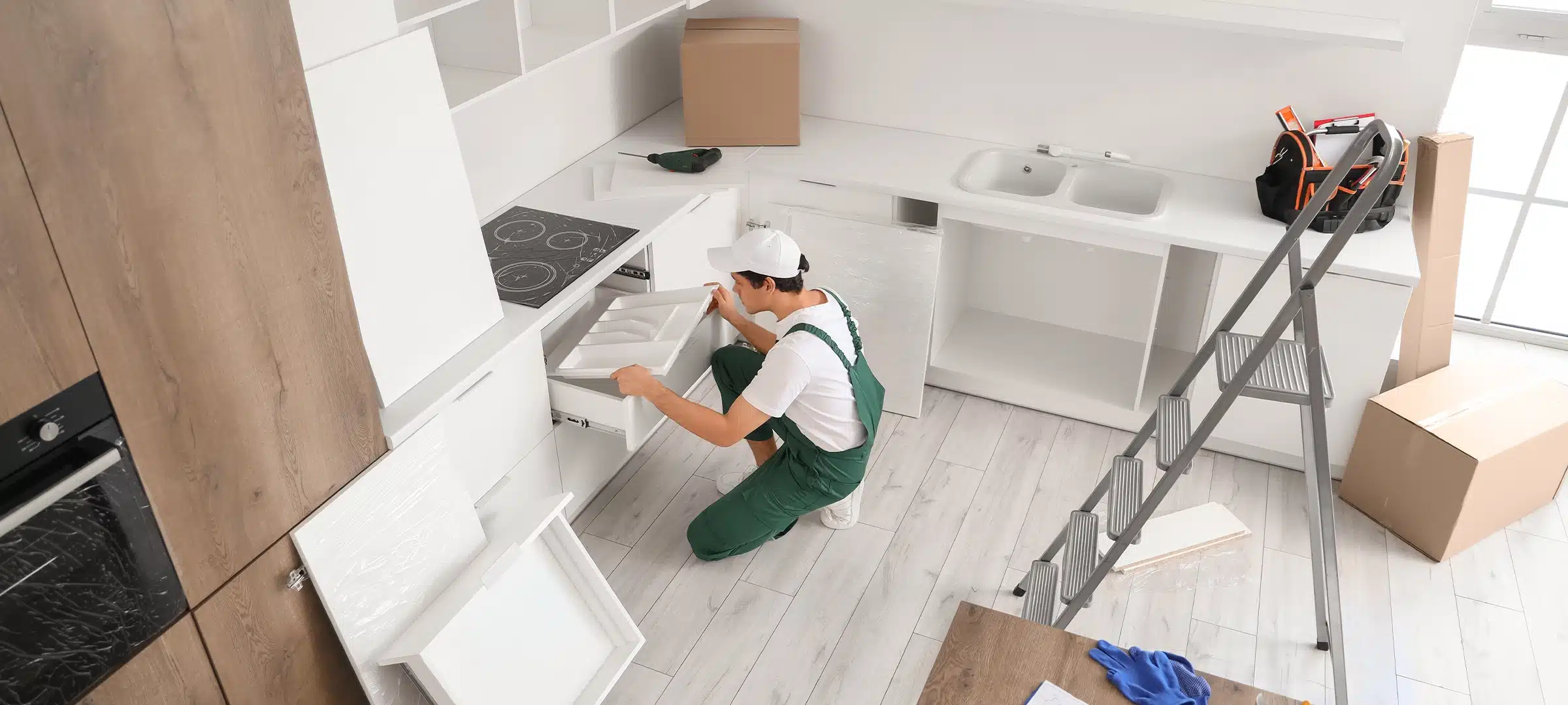 Male worker assembling cutlery drawer in kitchen