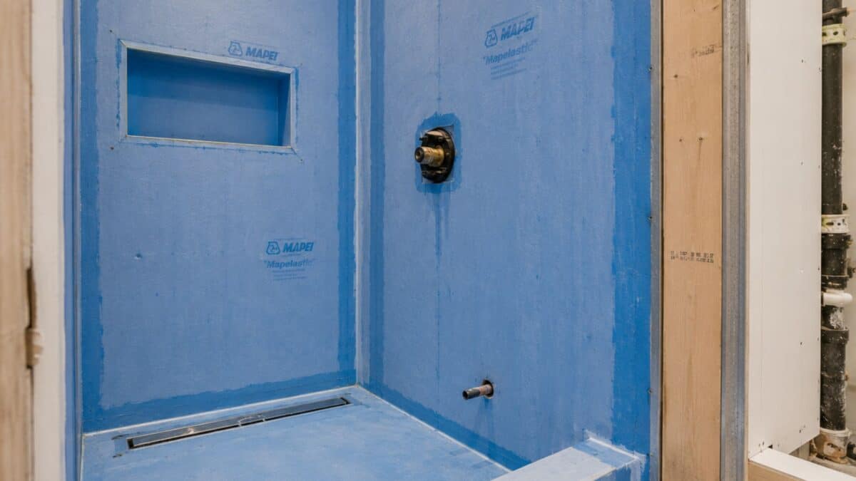 Professional waterproofing system installed in an NYC bathroom renovation before tile installation, showing shower preparation and plumbing infrastructure.