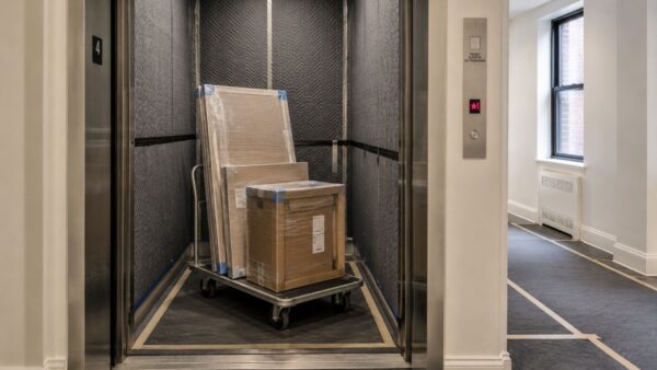 Protected freight elevator prepared for cabinet and appliance deliveries during an NYC kitchen renovation.