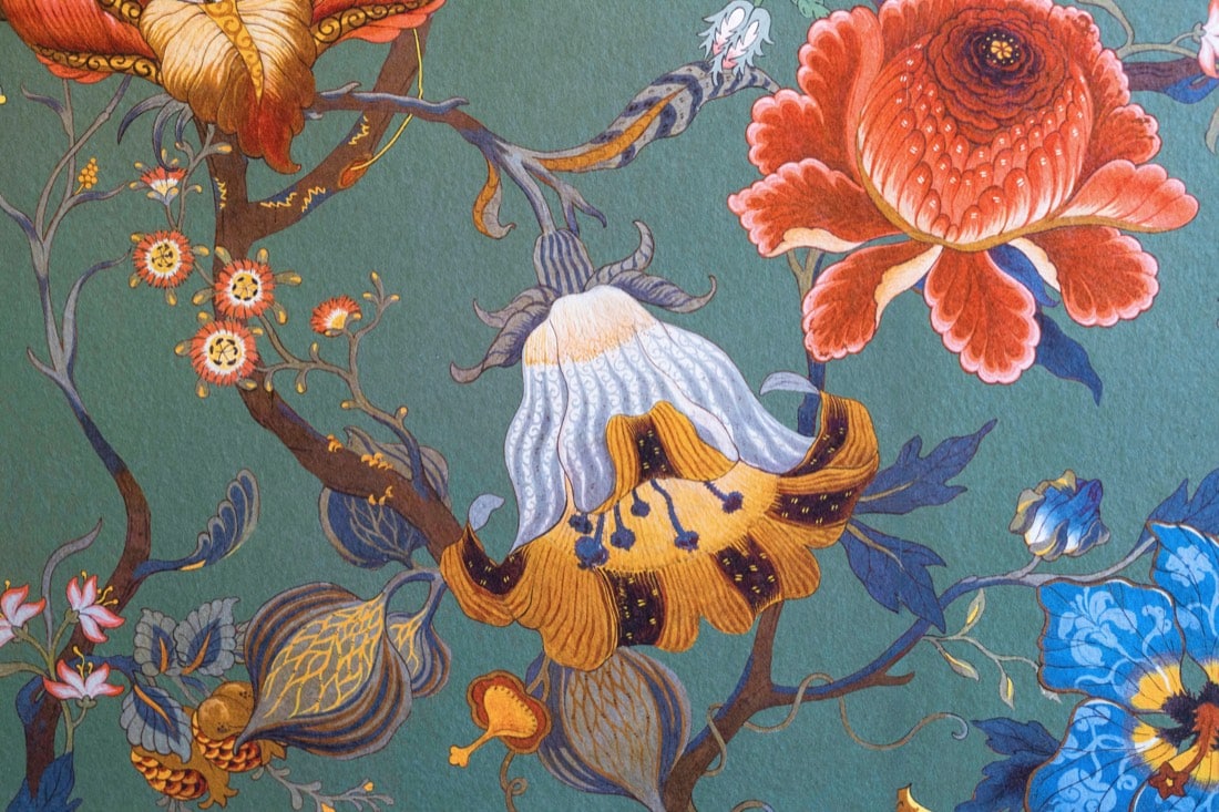 Close detail of the powder room wallpaper: large orange and coral blooms with blue and yellow flowers and branches on a deep teal ground