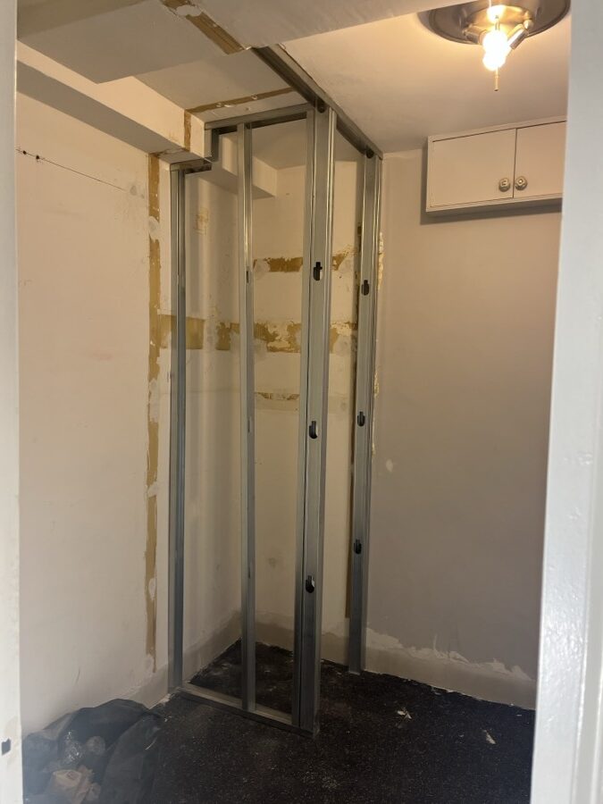 During the work at 220 Madison Avenue: New steel stud framing stood in the closet opening, under the existing ceiling light.