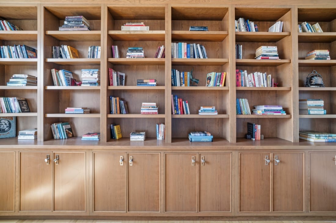 Finished dining room built-in: Plain and Fancy Quaker Shaker inset cherry bookcases in Winter Wheat, in a grid of bays over base cabinets with polished nickel pulls