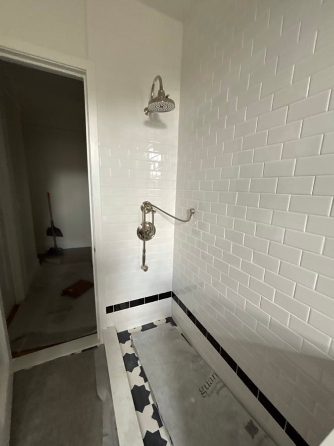 During the work at West End Avenue: Fully tiled with the black trim at the base and the sconce mounted. No glass yet.