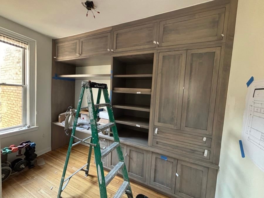 During the work at West End Avenue: Shelves being set, with the drawing taped to the wall beside them.